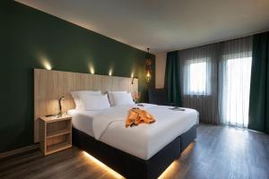 赖林根ACHAT Hotel Reilingen Walldorf的酒店客房,配有一张带浴袍的床