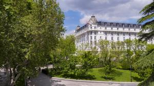 马德里Mandarin Oriental Ritz, Madrid的前面有树木的白色大建筑