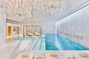 马德里Mandarin Oriental Ritz, Madrid的吊灯房间中的游泳池