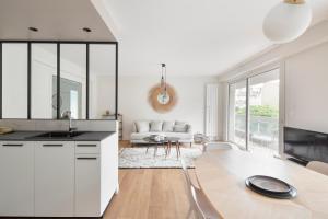 雷恩L'Eden - Appartement familial au pied du Thabor的一间带桌子的白色厨房和一个客厅
