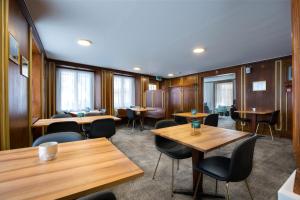 拉格斯Krone by b-smart的餐厅设有木桌、椅子和窗户。