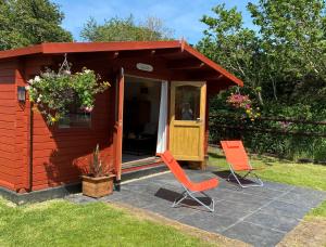多切斯特Primrose Cabin的两把橙色椅子坐在一个小棚前