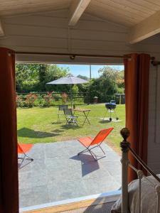 多切斯特Primrose Cabin的庭院配有桌椅和遮阳伞。
