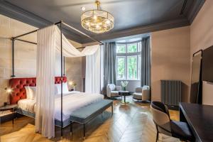 利沃夫狮子城堡酒店的一间卧室配有天蓬床和桌椅