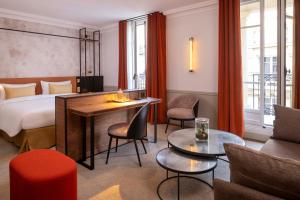 巴黎维多利亚广场酒店的酒店客房带一张床、一张桌子和椅子