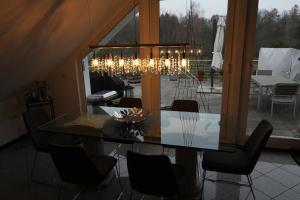 兰河畔马尔堡Zweit-Traumwohnung的一间带玻璃桌和吊灯的用餐室