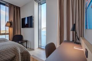 波多Quality Hotel Ramsalt的配有一张床、一张书桌和一扇窗户的酒店客房