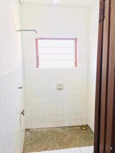 阿克拉Feel At Home & be close to the Labadi Beach (5min)的浴室设有白色瓷砖淋浴和窗户。