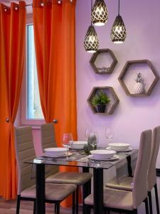 皮兰Villa Piran luxury apartments的用餐室配有橙色窗帘和桌椅