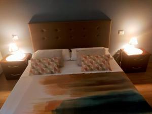 斯波莱托B&b La Rocca的一间卧室配有一张大床和两盏灯