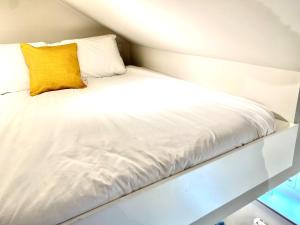 赫里福德Apartment @ Bastion Mews的一张白色的床,上面有黄色枕头