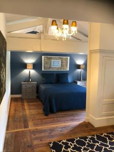 PierreclosDomaine en Reynouse的一间卧室配有一张蓝色的床和两盏灯。