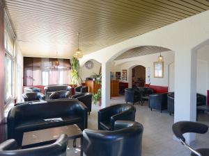 马奇纳奇奥尤利比休酒店的一间设有黑色皮革椅子和桌子的等候室