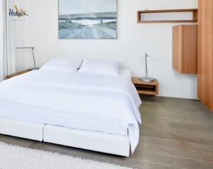 滨海卡约Hidden Bay Hotel的白色卧室内的一张大白色床