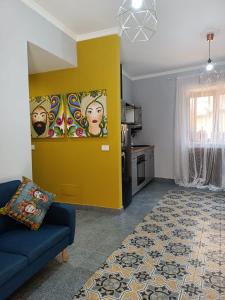 阿格里真托A Cantunera LittleHouse的客厅设有蓝色的沙发和黄色的墙壁