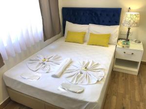 安塔利亚Turunç Hotel ANTALYA的一张带两个白板和餐巾的床