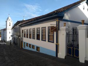 迪亚曼蒂纳Pousada Dona Dazinha的白色和蓝色的建筑,有钟楼