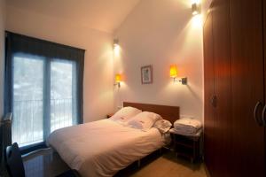 奥尔迪诺普拉德米纳斯旅游公寓酒店的一间小卧室,配有一张带窗户的床
