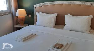 拉戈斯因方特旅馆的一张白色的床,配有白色枕头和一盘食物
