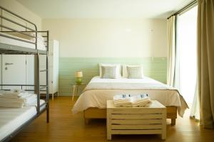 蓬塔德尔加达THE HOLY COW - Hostel & Suites的一间卧室配有一张床和一张双层床。