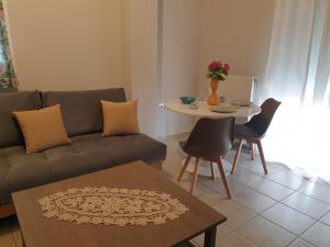 沃洛斯Comfortable apartment in the center of Volos very close to the port的客厅配有沙发和桌子