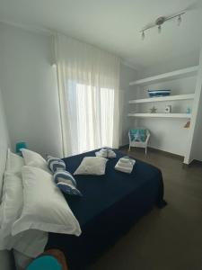 滨海波利尼亚诺Il Veliero的一间卧室配有蓝色的床、枕头和窗户