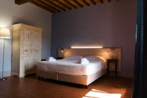 基安蒂盖奥勒Paradiso in Chianti的一间卧室设有一张大床和一个木制床头板