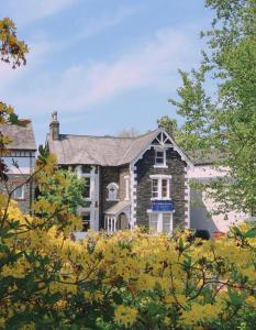 温德米尔Rayrigg Villa at Windermere的一座大砖房,前方有树木