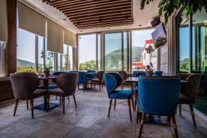布德瓦奥迪西酒店的餐厅设有蓝色的椅子和桌子以及窗户。