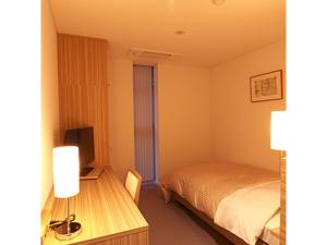 YabuPure Hotel - Vacation STAY 44183v的一间卧室配有一张床和一张书桌及电视