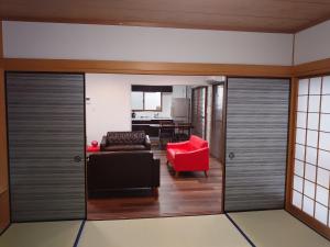 名古屋ROYAL SUITE SAKAE - Vacation STAY 11483的带沙发和红色椅子的客厅