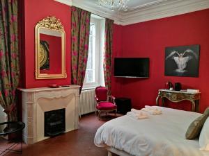阿莱斯les jardins de la fontaine的红色卧室设有一张床和一个壁炉