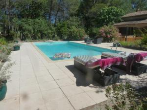 德拉吉尼昂Villa Les Oliviers的院子里设有2个长椅的游泳池