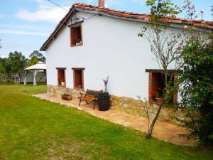 奥维多Casa Pepín - Sagasta Rural Oviedo的院子里的白色房子,长凳