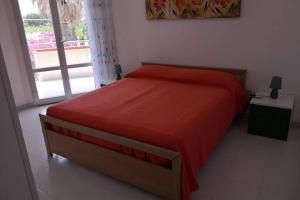 马劳萨Villa Angelina的一间卧室设有红色的床和窗户。