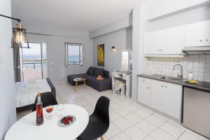 古瓦伊Sole Mare Seaside Apartments的厨房以及带桌椅的起居室。