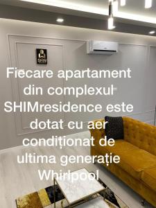 勒德乌齐SHIMresidence LUXURY的客厅配有沙发和墙上的标志