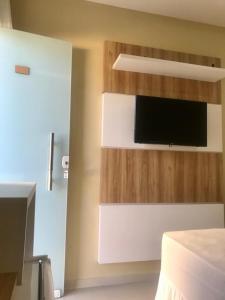 乌巴雅拉Pousada Life的一间卧室配有一张床,墙上配有电视