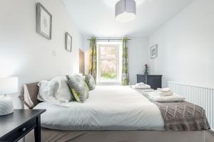 皮滕威姆Madeira In Fife的白色的卧室设有一张大床和一个窗户