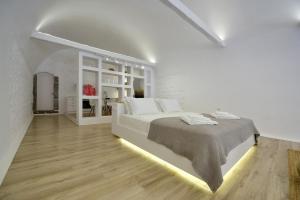 伊兹拉Hydra Hospitality Port Apartment的白色卧室配有一张带灯的大床
