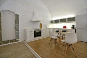 伊兹拉Hydra Hospitality Port Apartment的厨房配有白色橱柜和桌椅