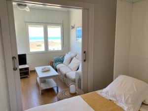 蓬塔翁布里亚Apartamento Canaleta Aitana frente al mar的一间卧室配有一张床,客厅配有沙发