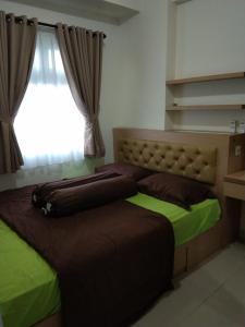 雅加达Apartemen Green Pramuka City的一间卧室设有两张床和窗户。