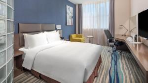 沈阳沈阳北站智选假日酒店的一张大白色的床,位于酒店客房内