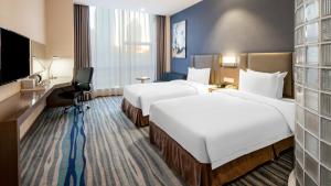 沈阳沈阳北站智选假日酒店的酒店客房设有两张床和一台平面电视。