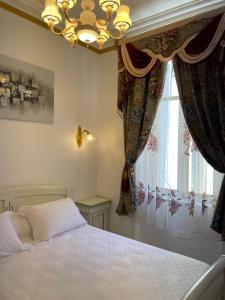 纳博讷Appartement Maison de L'Église du Couvent的一间卧室配有一张床、一个吊灯和一扇窗户