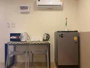 暖武里府Bansuay Phra Nang Klao的厨房配有桌子和冰箱