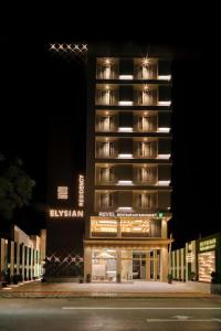 艾哈迈达巴德Hotel Elysian Residency的一座高大的建筑,晚上有灯光的外墙