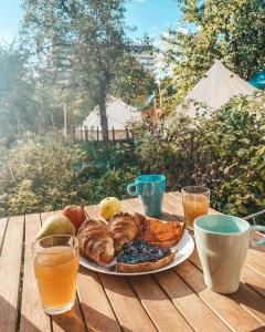 布拉索夫Dragonfly Gardens - The Wagons的木桌上的一盘食物,配以饮料