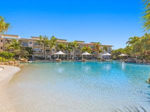 金斯克里福Resort & Spa 6316 with resort Tropical Pool的一座棕榈树和建筑的大型游泳池